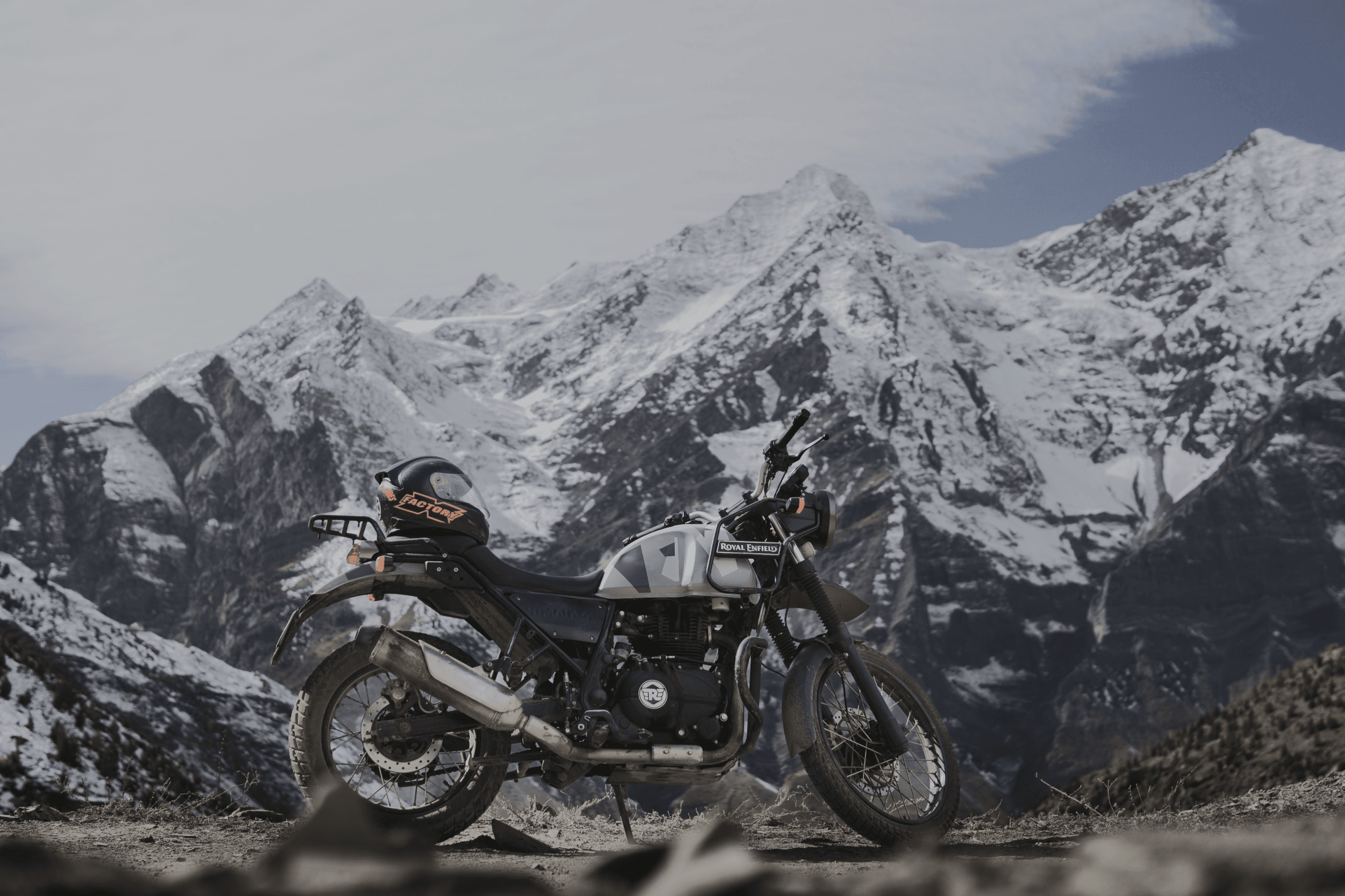 Royal Enfield Himalayan against a snow-capped mountain range